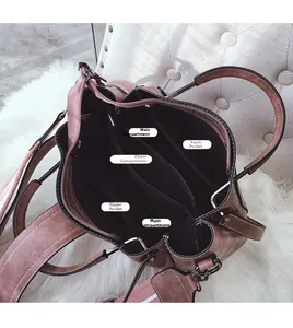 Detail view of pink bucket bag showing large interior compartments and wide shoulder strap