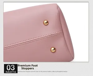 Close-up of pink pebbled leather handbag bottom with protective gold metal feet studs