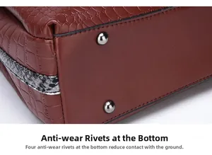 Dettaglio della base della borsa con piedini metallici argentati e texture a coccodrillo