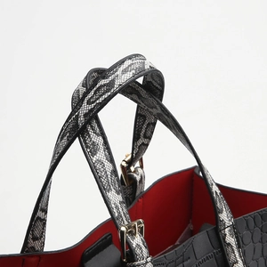 Elegant black crocodile-textured handbag with snake pattern handles and red interior lining