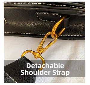 Macro detail of the golden detachable hardware and white stitching on black leather bag