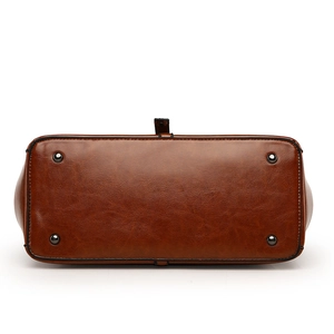 Vue du dessous d'un grand sac cabas en cuir marron avec quatre clous de protection en métal