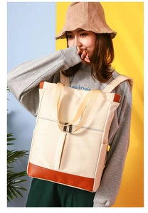 Detail view of cream waterproof nylon backpack showing multi-pocket design and texture
