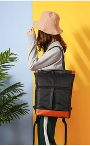 Detail of waterproof nylon backpack with brown leather trim shown on a model
