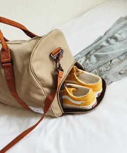 Dettaglio del borsone da viaggio in tela kaki con scomparto laterale separato per scarpe