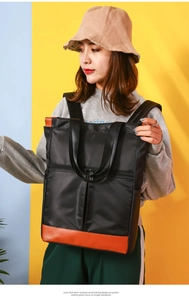Detail of multi-functional black and orange nylon tote bag with side pocket and zippers