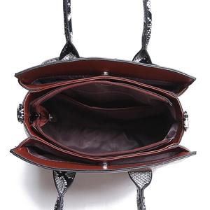 Internal view of snake pattern tote bag showing compartments and red fabric lining