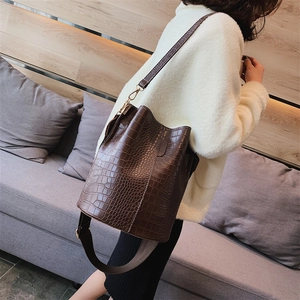 Brown crocodile pattern bucket bag with wide strap and gold hardware accessories