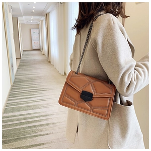 Close-up of brown quilted leather shoulder bag with metallic studs and chain strap