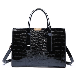 Black crocodile embossed patent leather tote bag with gold metal trim and top handles