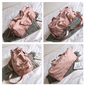 Detailed views of pink fitness travel bag with double handles and metallic hardware