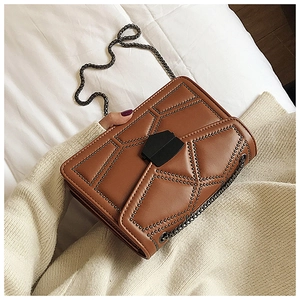 Detail showing brown studded small square bag with metal chain strap and hex buckle