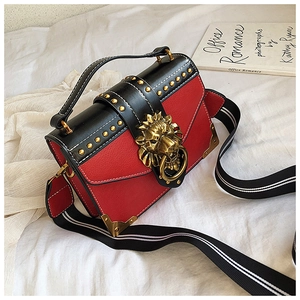 Detailed shot of vintage red and black bag with gold lion head buckle and rivets