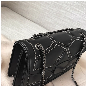 Detail view of the black studded shoulder bag showing its multi-layered accordion structure