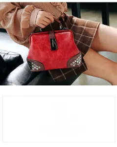 Detail shot of vintage red PU leather doctor bag with metal rivets and gold chain lock