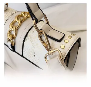 Macro shot of stylish handbag featuring white faux leather and snakeskin texture details