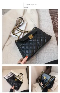 Close-up of black quilted leather crossbody bag with golden chain and metal lock
