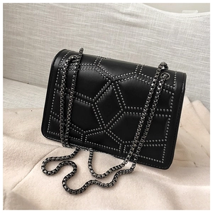 Detail of black quilted leather crossbody bag with silver studs and chain strap