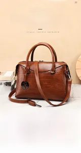 Detail view of premium dark brown crocodile pattern Boston bag in top layer cowhide leather