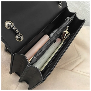 Top view of black chain bag interior showing multi-layer compartments and storage space