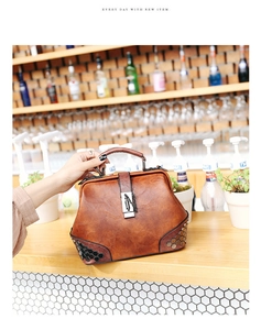 Detail of vintage brown doctor bag with rivet studs and silver lock on leather