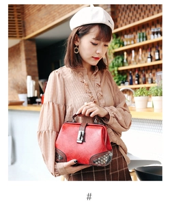 Detailed shot of vintage red doctor bag featuring metallic hexagon rivets and lock