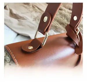 Detailed close-up of premium gold-tone metal hardware on straw and leather handbag