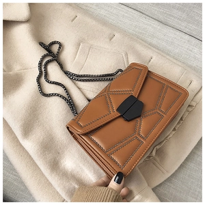 Detailed top view of caramel brown crossbody bag with metal rivets on wool coat