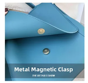 Close-up of golden magnetic hardware buckle on blue leather tote bag detailing