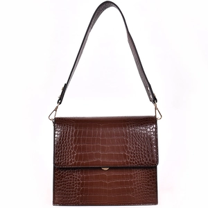 Détail d'un sac en cuir à texture crocodile marron avec finitions en métal doré