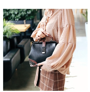 Detail of vintage doctor bag with hexagonal metal rivets and brown leather accents