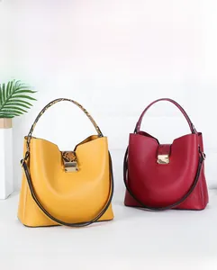 Close-up of bucket handbags with snakeskin textured handles and adjustable straps