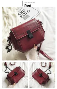 Dettaglio borsa a tracolla in pelle PU rossa con catena nera e cuciture intrecciate sul bordo