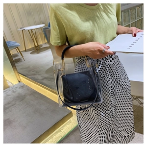 Detailed shot of transparent PVC bucket bag with black leather inner pouch for privacy