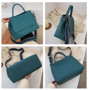 Detail view of teal leather tote bag featuring a geometric woven strap and metal hardware