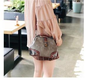 Detail of retro doctor bag featuring silver rivets and elegant metal chain buckle