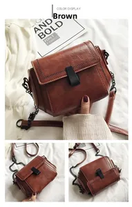 Vista dettagliata della borsa in pelle marrone con cuciture decorative e tracolla a catena