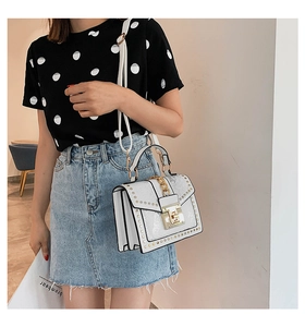 Detailed close-up of white snake pattern leather bag with golden chain and metallic lock