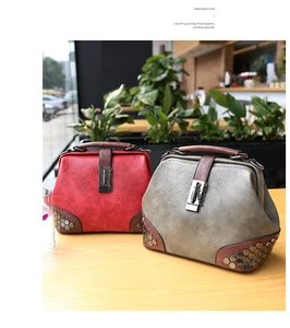 Detailed view of vintage doctor bags with retro rivets and chain buckle in a cafe setting