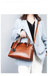 Brown crocodile pattern tote bag with metal 'F' charm and adjustable shoulder strap