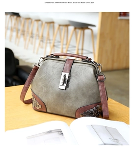 Detail of olive green doctor bag with vintage metal rivets and industrial lock closure