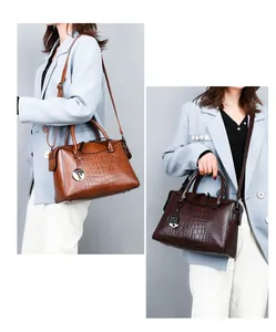 Detail of crocodile embossed texture on brown and dark coffee tote bags with metal charms
