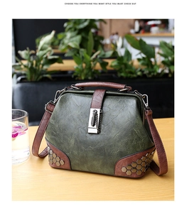 Detail of vintage doctor bag featuring olive green leather and hexagonal metal rivets