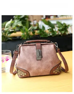 Detail of vintage doctor bag with brown faux leather texture and metal rivet studs