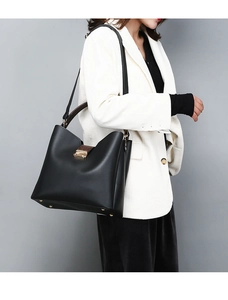 Detail of black PU leather bucket bag with snake skin pattern trim and gold metal buckle