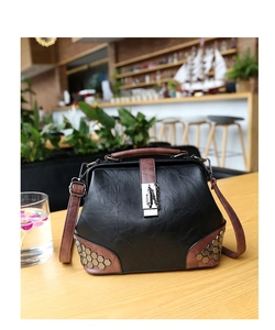 Close-up of vintage doctor bag featuring hexagon rivets and metallic lock on wooden table