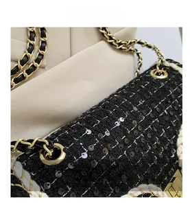 Détail du sac bandoulière en tweed noir avec paillettes et chaîne en cuir doré