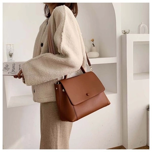 Brown leather crossbody bag detail featuring ethnic geometric patterned wide strap