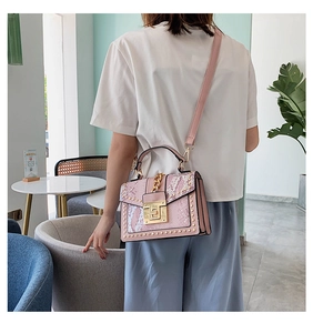 Close-up of pink snakeskin pattern bag with gold metal lock and rivet detailing