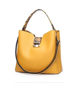 Detail view of yellow PU bucket bag featuring faux snakeskin texture on handle and gold clasp